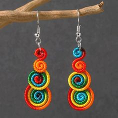 multicolored beaded earrings hanging from a tree branch