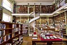 a spiral staircase in the middle of a library filled with books