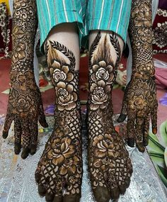 the feet and hands of a woman with henna tattoos