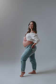 a pregnant woman poses for a studio photo