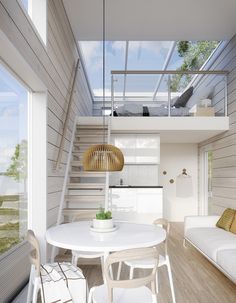 a white table and chairs in a room with wooden walls, stairs to the second floor