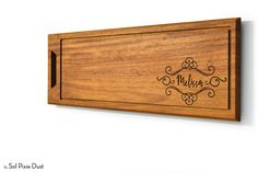 a wooden cutting board with the name melon engraved on it's front and side