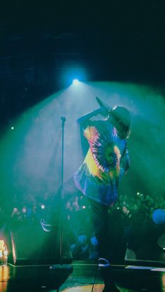 a man standing on top of a stage in front of a crowd at a concert