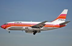 an orange and white airplane is flying in the sky with its landing gear down on it's side