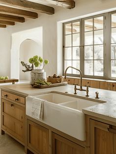 a kitchen with wooden cabinets and white counter tops next to a large window that looks out onto the outdoors