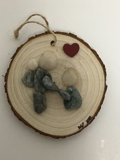 an ornament made to look like a tree slice with rocks and a heart on it