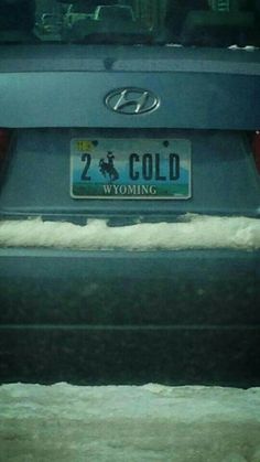 the back end of a car that is covered in snow and has a license plate on it