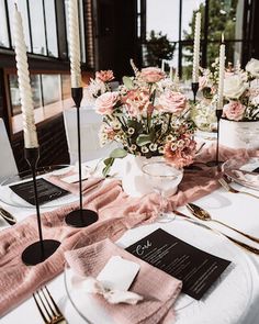 the table is set with pink napkins and place settings for an elegant dinner party