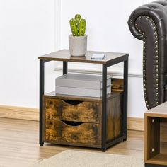 a small table with two drawers and a potted plant