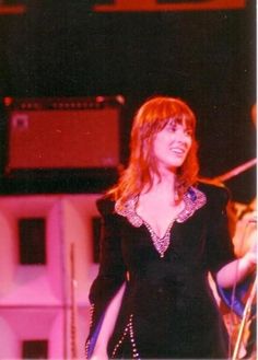 a woman in black dress standing on stage