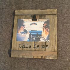 a wooden frame with the words this is us on it and an image of two people in a car