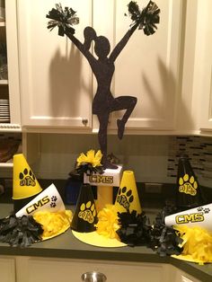 a cheerleader themed party with yellow and black pom poms on the counter