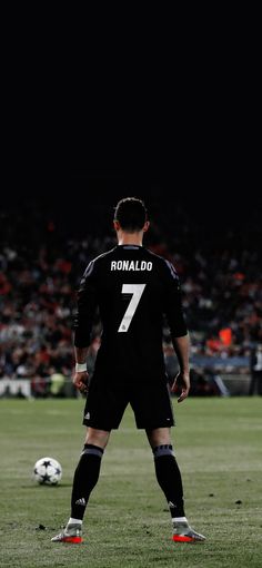 a man standing on top of a field next to a soccer ball