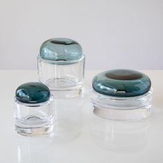 three glass jars with lids are sitting on a table