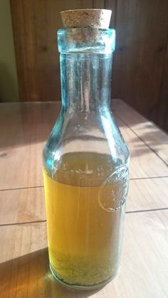 a glass bottle filled with liquid sitting on top of a wooden table