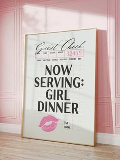 a poster with the words now serving girl dinner in front of a pink wall and wooden floor