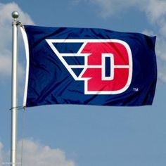 a blue and red flag with the letter d on it flying in the air next to some clouds