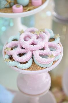 there are donuts that are on top of the cake stand and decorated with pink icing