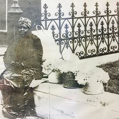 an old photo of a man sitting on a bench next to a potted plant