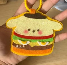 a hand holding a sandwich shaped ornament