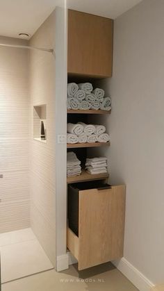 a bathroom with white towels stacked on shelves