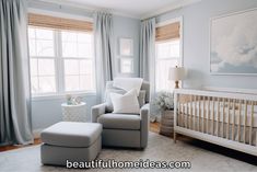 a baby's room with blue walls and white furniture