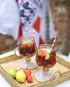 two glasses filled with fruit sitting on top of a tray