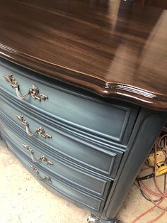 an old dresser is painted blue and brown