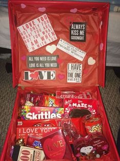 an open red suitcase filled with lots of valentine's day candy and candies