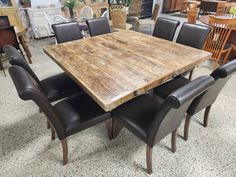 a wooden table surrounded by black leather chairs