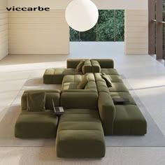 a large green couch sitting on top of a white floor in a living room next to a window