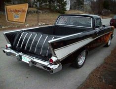 an old black and white car parked on the street