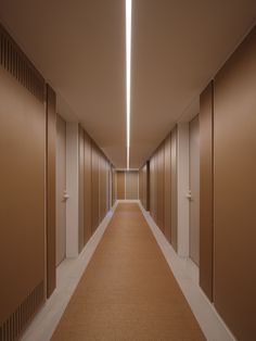 an empty hallway with several doors leading to the other rooms on either side and one light at the end