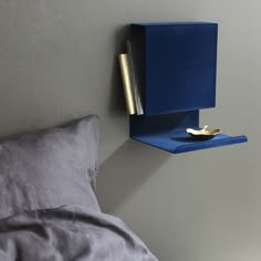 a bed with a blue box on the wall next to it and a gold object