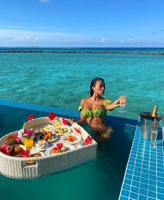 a woman sitting in the water with a tray of food