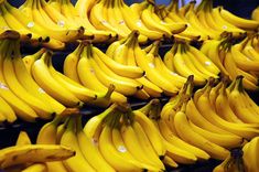 bunches of bananas are lined up on shelves in a grocery store, ready to be sold