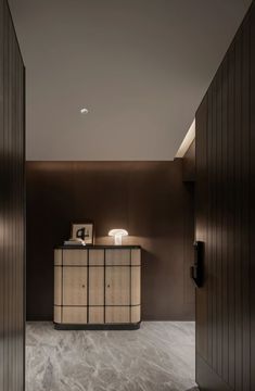 an elegant reception area with marble flooring and dark wood paneling, along with a white lamp