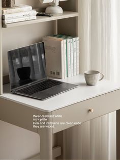 an open laptop computer sitting on top of a white desk next to a book shelf