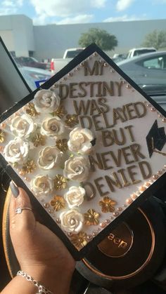 someone is holding up a graduation cap with flowers on it