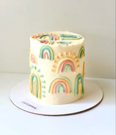 a cake decorated with rainbows and clouds on a plate