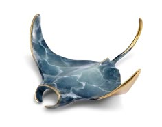 a blue and gold brooch with an animal's tail sticking out of it