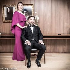 a man in a tuxedo sitting next to a woman in a pink dress