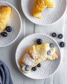 three plates with pastries and blueberries on them