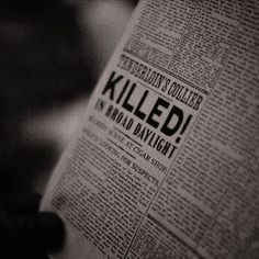 a person reading a newspaper with the word killed written on it