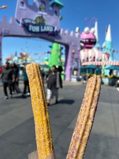 a stick of corn on the cob in front of an amusement park entrance