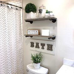 a bathroom with two shelves above the toilet