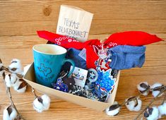 a box filled with items sitting on top of a wooden table next to cotton floss