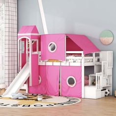 a child's bedroom with a pink tent and slide in the middle of it