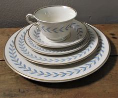 a stack of blue and white plates on top of a wooden table