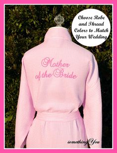 a pink robe with the words mother of the bride on it and an image of bushes behind it